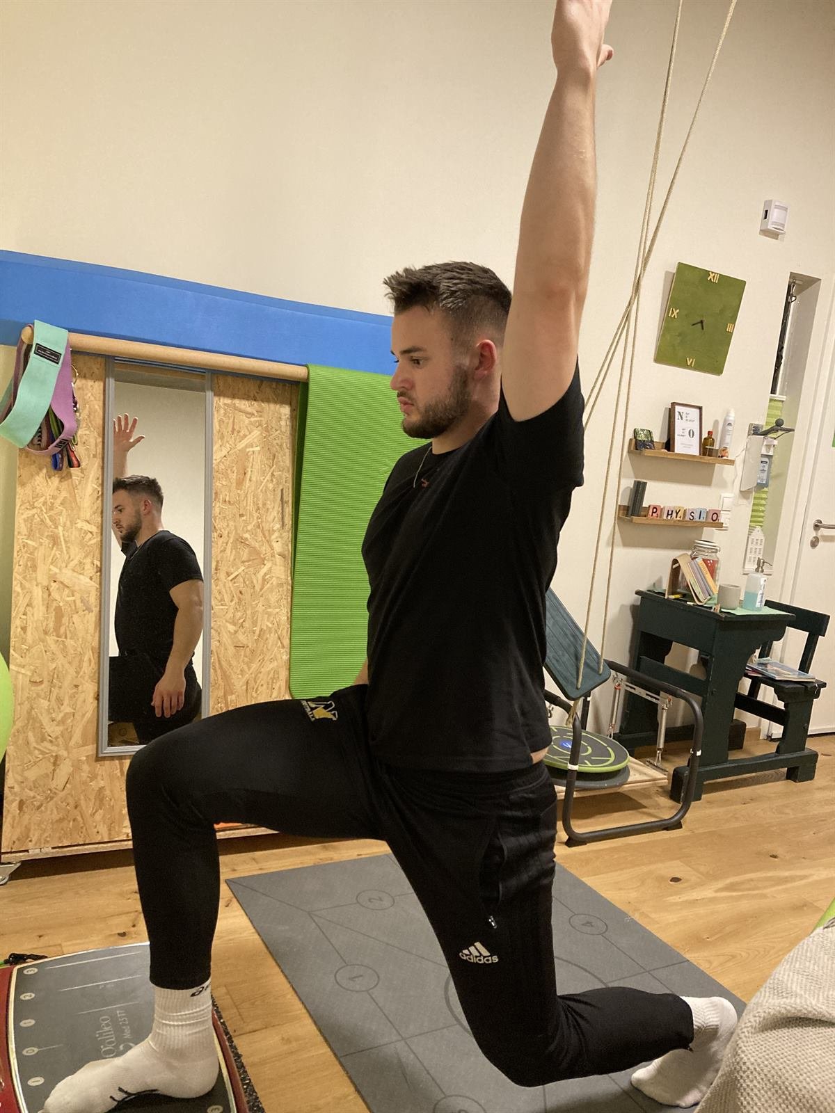 Mann im Ausfallschritt mit gestrecktem Arm beim Training in der Praxis